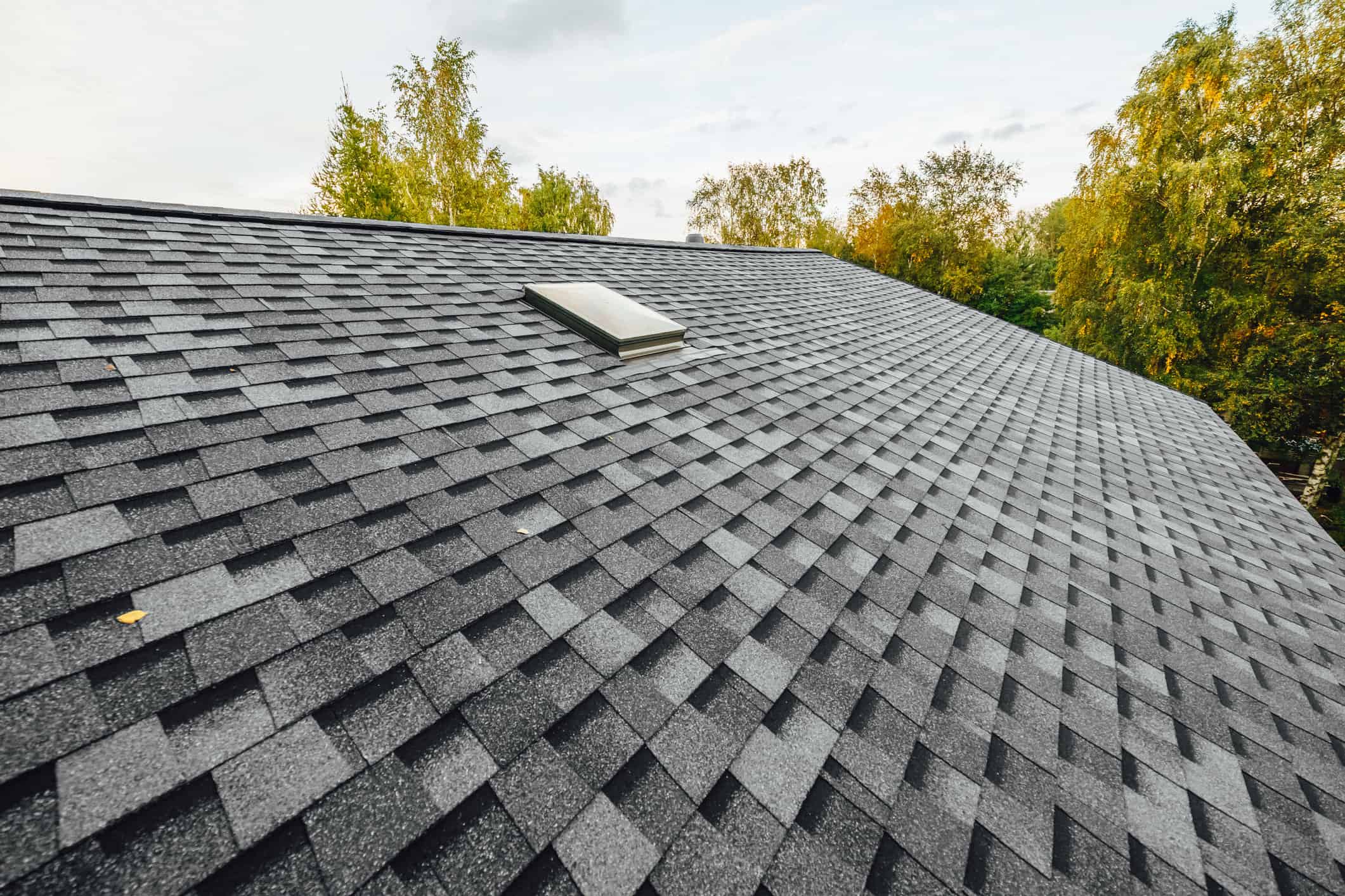 roof of new house with shingles roof-tiles and ventilation window